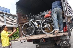 Loading our bikes into the back of that kind durian truck that offered to take us. 